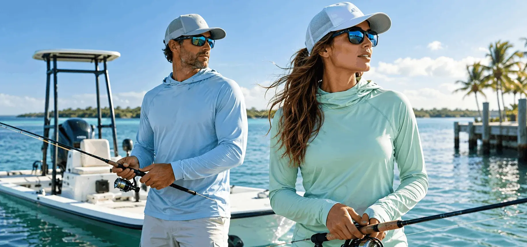 Man and woman wearing lightweight UPF fishing shirts while fishing beside a boat on tropical water.